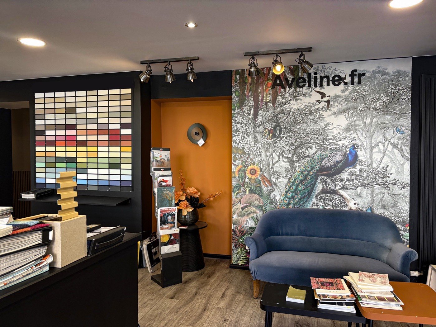 Le showroom du magasin : nuancier grandeur nature, papier peint panoramique et canapé
