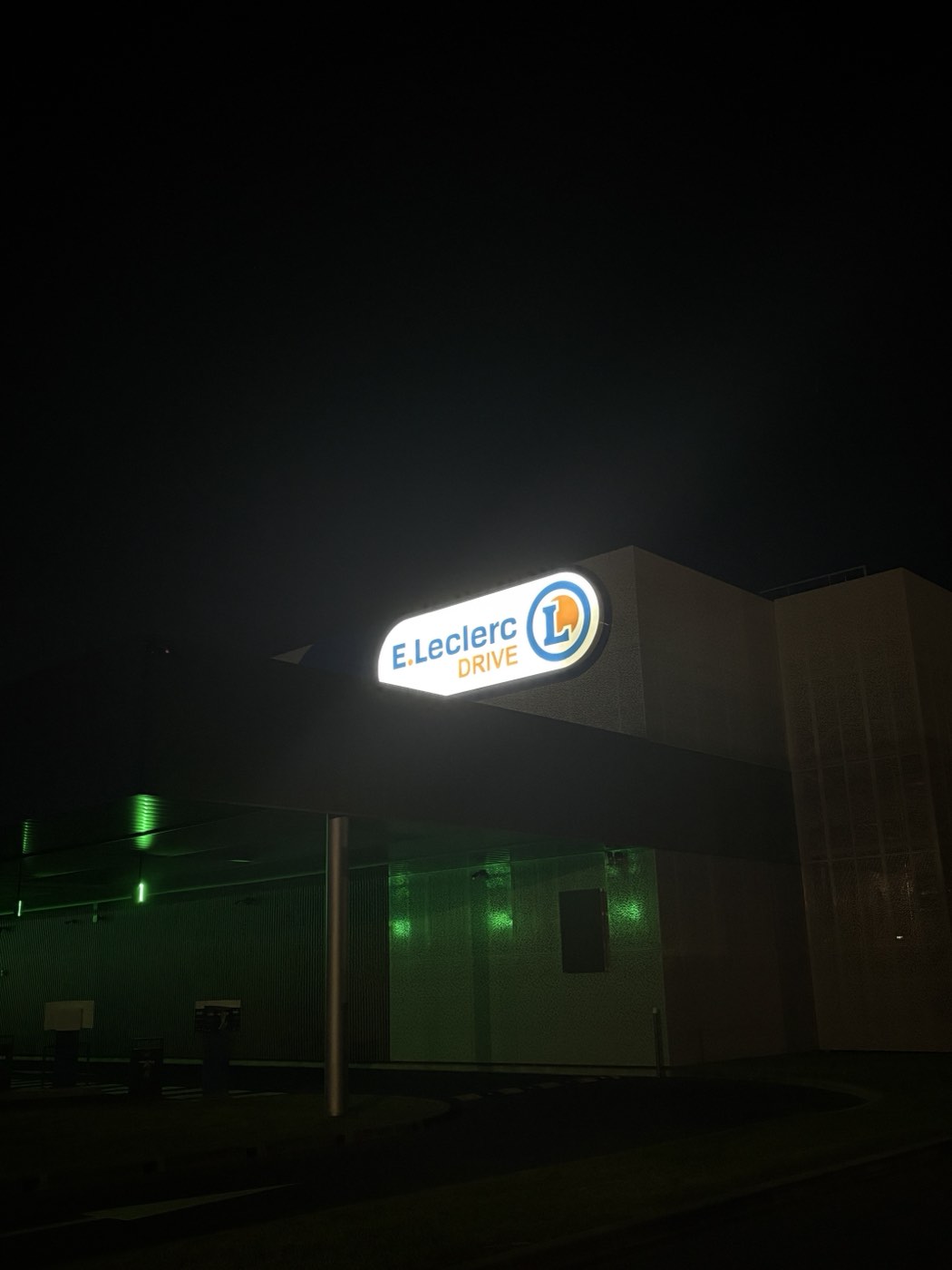 Caisson lumineux E.Leclerc Drive allumé la nuit, sur son mât