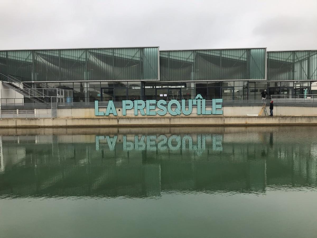 Enseigne La Presqu'île en lettres découpées, posée au bord de l'eau
