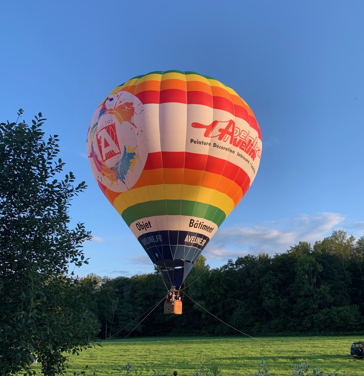 Montgolfière aux couleurs Aveline en vol au-dessus d'un champ